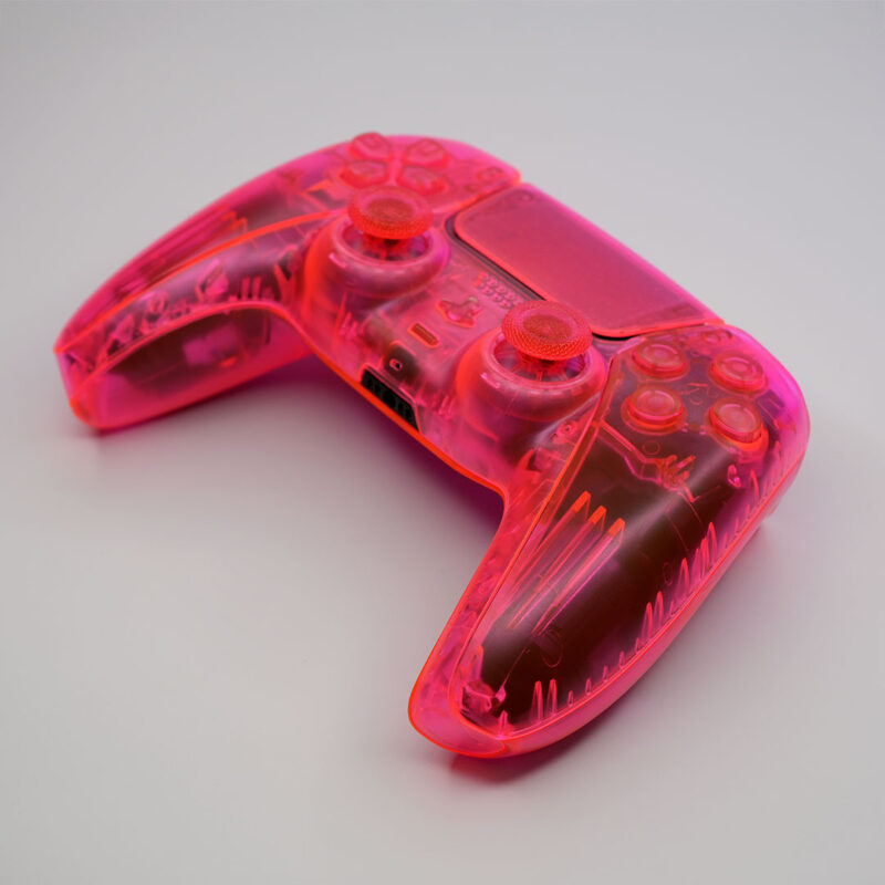 Front angle view of the Killscreen Triple Neon PS5 controller showing transparent pink-orange shell and clear thumbsticks.